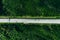 Aerial view of toll road highway with cars and trucks through green forest