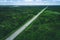 Aerial view of toll road highway with cars and trucks through green forest