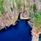 Aerial view from the top of a dark blue moor lake in the heath with a small hut on the shore