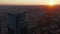 Aerial view of top of tall business skyscraper with city and sunset in background. Romantic evening footage.