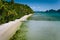 Aerial view of tourist boat at tropical sandy beach with coconut palm trees in El Nido, Palawan, Philippines