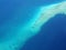 Aerial view of tourist ferry boat floating near coral reef