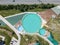 Aerial view of a tourist recreation center in with three swimming pools and wooden sun loungers on nature in the Altai mountains