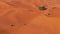 Aerial view of tourists driving through the popular sand dunes of Erg Chebbi desert with their offroad vehicles.