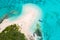 Aerial view of tourists, jet boat, idyllic empty sandy beach, remote island, azure turquoise blue lagoon, New Caledonia, Oceania.