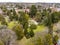 Aerial view of the town of Armidale with buildings, a cathedral, War Memorial Fountain, and trees