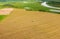 Aerial View Tractor Collects Dry Grass In Straw Bales In Wheat Field. Special Agricultural Equipment. Hay Bales, Hay