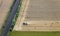 Aerial View : Tractor in a field along a railroad