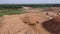 Aerial view of a tractor loading sand and dump trucks.