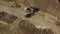 Aerial view of a tractor that loads soil into the back of a truck. Road works. Autumn