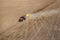 Aerial view of tractor with mounted seeder performing direct seeding of crops on plowed agricultural field. Farmer is using