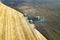 Aerial view of a tractor plowing black agriculture farm field after harvesting in late autumn