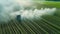 Aerial view of a tractor spraying agricultural fields. spraying herbicides on the field