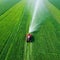 Aerial view tractor spraying the chemicals on the large green