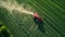 Aerial view of a tractor spraying crops in a farm field