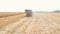 Aerial view of tractor transporting corn cargo at field during harvesting. Drone tracking agricultural machine driving