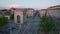 Aerial view of traffic on roads and intersections around historic Porta Ticinese gate at dusk. Milano, Italy