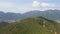 Aerial view on a trail to the top of a mountain, from which top a city in a valley can be seen