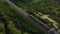 Aerial view: train at the rural scene in summer. The train rides through the rural countryside in the sunrise.