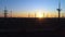 Aerial view of transmission towers, silhouette of electricity pylons with power lines in background of orange sunset