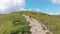 Aerial view of a Traveler with Backpack Climbing along Mountain Slope. Epic Shot