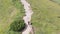 Aerial view of a Traveler with Backpack Climbing along Mountain Slope. Epic Shot