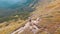 Aerial view of a Traveler with Backpack Climbing along Mountain Slope. Epic Shot