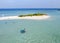 Aerial view of travelers arriving at a small sandy island in the Indian Ocean by motor boat