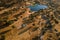 Aerial view of a tree-covered landscape with a small lake in Dehesa de la Luz, Extremadura, Spain