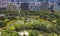 Aerial view of trees in Taipei park garden and reflection of skyscrapers buildings. Green area in smart urban city at noon, Taiwan