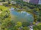 Aerial view of trees in Taipei park garden and reflection of skyscrapers buildings. Green area in smart urban city at noon, Taiwan