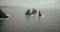 Aerial view of the troll toes mountain in the water in Iceland. Copter flying around the cliff in sea in foggy day.