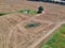 Aerial view on truck tracks on wheat field with trees and meadows