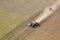 An aerial view of trucks and tractors harvesting potatoes.