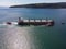 Aerial view of tug boat assisting big bulk carrier cargo ship. Large ship escorted by tugboat.