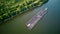 Aerial view of tugboat pushing barges up a river