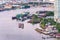 Aerial view of tugboat shipping barges, Bangkok city at Chao Phaya riverfront and bridge across the river with central business d