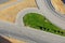 Aerial view of the turning of asphalt roads with white markings, metal fences and signs