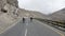 Aerial view of two boys running on a empty road in the mountains. Freedom and travelling concept