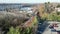 Aerial view of two car light rail train leaving a station near a busy highway bridge over a river