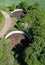 Aerial view of two open circular slurry tanks with trees growing at the edges