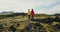 Aerial view of two woman walking on the lava field in Iceland. Tourists female hiking on the mountains covered moss.