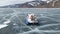 Aerial view of the typical hovercraft vehicle while travelling across on clear craked ice surface. Clip. Lake Baikal