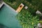 Aerial view of unrecognizable slim young woman in beige bikini relaxing and sunbathe near luxury swimming pool in green