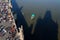 Aerial view of unrecognizable tourist walking on the Charles Bridge with small boat on Vltava river, Prague, Czech Republic