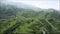 Aerial view of unusual mountain green slope with wavy formations covered by grass and rare trees. Action. Natural