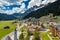 Aerial view of valley with Chalet, green slopes of the mountains of Italy, Trentino, Fontanazzo, huge clouds over a