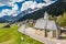 Aerial view of valley with Chalet, green slopes of the mountains of Italy, Trentino, Fontanazzo, huge clouds over a