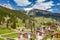 Aerial view of valley with Chalet, green slopes of the mountains of Italy, Trentino, Fontanazzo, huge clouds over a