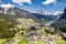 Aerial view of valley with Chalet, green slopes of the mountains of Italy, Trentino, Fontanazzo, huge clouds over a valley, roofs